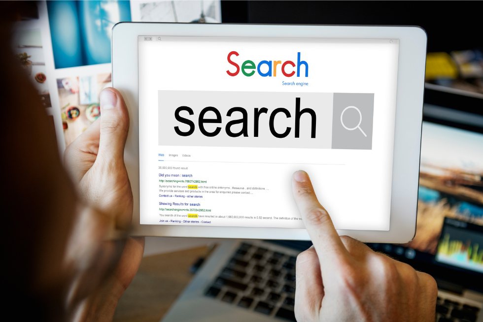 Persona utilizando un motor de búsqueda en una tablet, simbolizando la importancia de la publicidad en Google para negocios en Miami